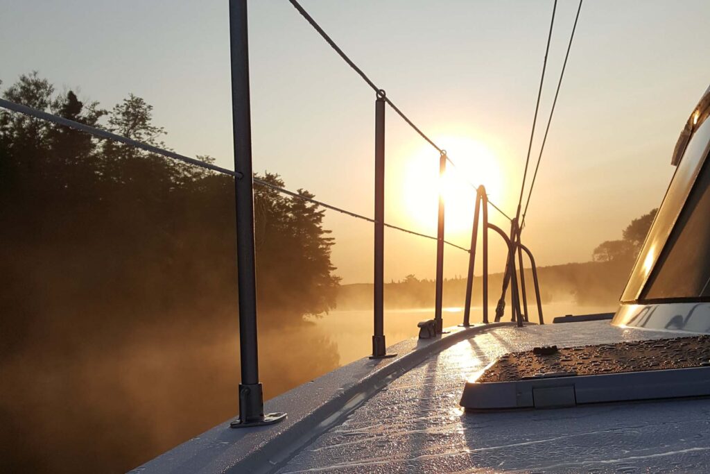 Sunrise through mist on the Bras D'Or Lake as seen from the deck of the Cape Bretoner luxury catamaran