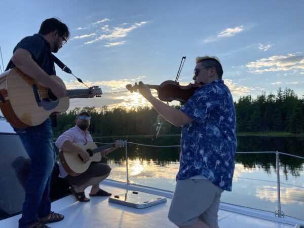 Keith Mullins, Jesse Cox, Morgan Toney performing on the deck of the Cape Bretoner 1 catamaran